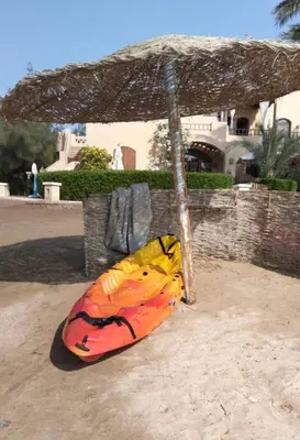 a bag sitting under an umbrella in the sand at The Seafront Magical Loft! in Hurghada