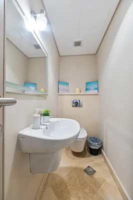 a bathroom with a white sink and a toilet at Cozy 1BR Apartment in Mangroovy with pool in Hurghada