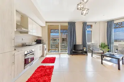 a kitchen with a red rug on the floor at Cozy 1BR Apartment in Mangroovy with pool in Hurghada