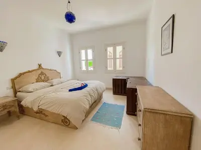 a bedroom with a large bed and a wooden table at 1-Bedroom Apartment in Abu Tig Marina + Roof Top in Hurghada