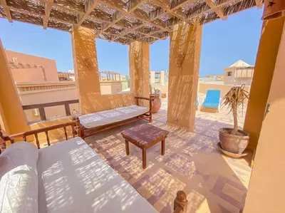 a room with a porch with a bed and a table at 1-Bedroom Apartment in Abu Tig Marina + Roof Top in Hurghada