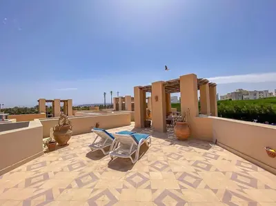 a patio with two lounge chairs on a roof at 1-Bedroom Apartment in Abu Tig Marina + Roof Top in Hurghada