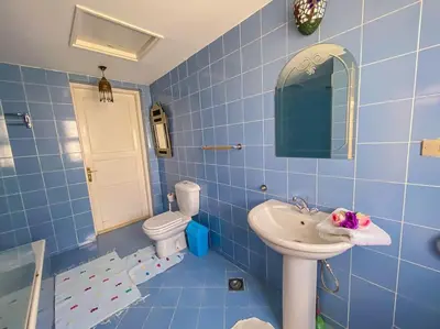 a blue tiled bathroom with a sink and a toilet at 1-Bedroom Apartment in Abu Tig Marina + Roof Top in Hurghada