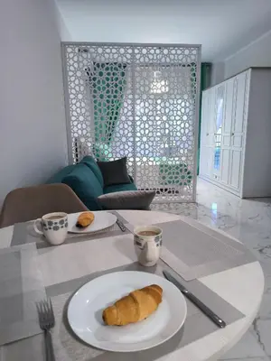 a table with a plate of croissants and cups of coffee at Juliana beach studio front of the beach in Hurghada