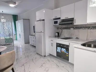 a white kitchen with a refrigerator and a sink at Juliana beach studio front of the beach in Hurghada