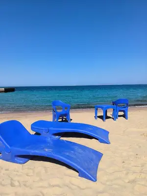 a group of blue plastic chairs on the beach at Juliana beach studio front of the beach in Hurghada