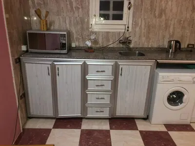 a kitchen with a microwave and a washing machine at Obelisk house in Jazīrat al ‘Awwāmīyah