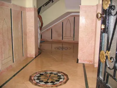a hallway with a door and a tile floor at Obelisk house in Jazīrat al ‘Awwāmīyah