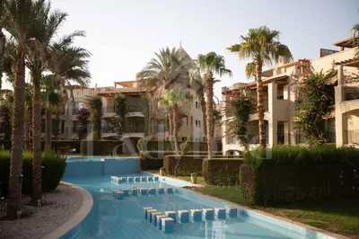 a resort swimming pool with palm trees and buildings at Ladybird - Veranda Skyline in Hurghada