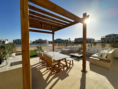 a patio with a table and chairs on a roof at Charming 3BR Villa/Free Pool & Lagoon Access@Gouna in Hurghada
