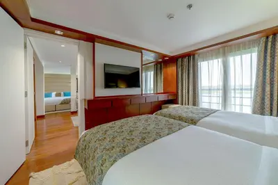 a bedroom with two beds and a flat screen tv at Sonesta Sun Goddess Cruise Ship From Luxor to Aswan - 04 & 07 nights Every Monday in Luxor