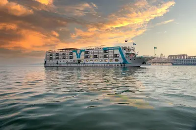 a large cruise ship on the water with a sunset at Sonesta Sun Goddess Cruise Ship From Luxor to Aswan - 04 & 07 nights Every Monday in Luxor
