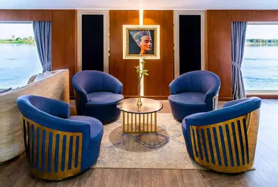 a living room with blue chairs and a table at Sonesta Sun Goddess Cruise Ship From Luxor to Aswan - 04 & 07 nights Every Monday in Luxor