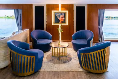 a living room with blue chairs and a table at Sonesta Sun Goddess Cruise Ship From Luxor to Aswan - 04 & 07 nights Every Monday in Luxor