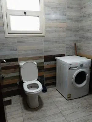 a bathroom with a toilet and a window at Makramia 2 bedroom apartment in Hurghada