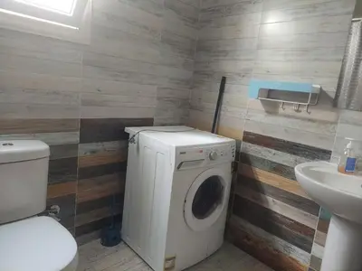a bathroom with a washing machine and a sink at Makramia 2 bedroom apartment in Hurghada