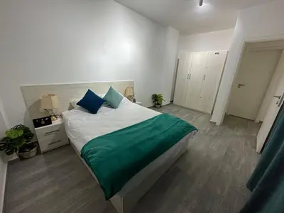 a bedroom with a large bed with a green blanket at Imperial Resort Apartment XL 1 Bed in Hurghada