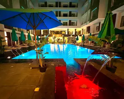 a swimming pool with an umbrella in a hotel at Imperial Resort Apartment XL 1 Bed in Hurghada