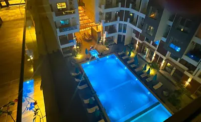 an overhead view of a man standing on the edge of a swimming pool at Imperial Resort Apartment XL 1 Bed in Hurghada