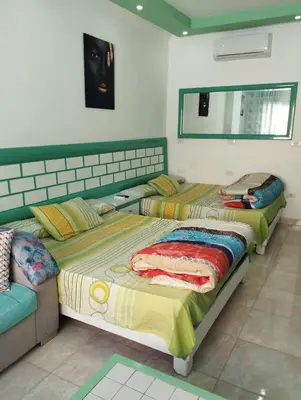 two beds in a room with a couch and a mirror at plaza hurgahda in Hurghada