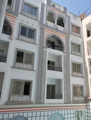 a tall white building with windows and balconies at plaza hurgahda in Hurghada