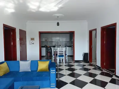 a living room with a blue couch and a checkered floor at Villa Kaslan Apartments in Luxor