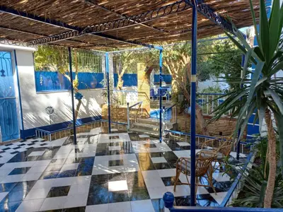 a patio with a table and chairs and a palm tree at Villa Kaslan Apartments in Luxor