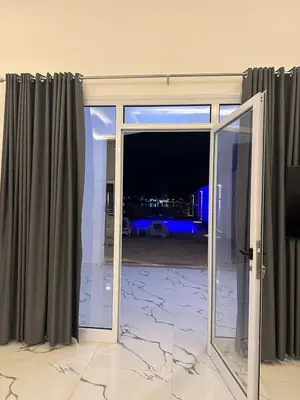 an open sliding glass door with a view of the city at Al Baba Nile Villa in Luxor