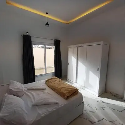 a bedroom with a bed and a large window at Al Baba Nile Villa in Luxor