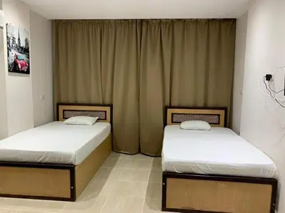 two twin beds in a room with curtains at شاليه داخل ميراج اكوا بارك عائلات فقط غير مخصص للشباب in Hurghada
