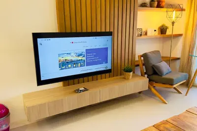a living room with a flat screen tv and a chair at Cozy 3 bedrooms in swan lake in Hurghada