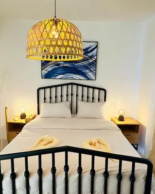 a bedroom with a bed with a chandelier and towels on it at Cozy 3 bedrooms in swan lake in Hurghada