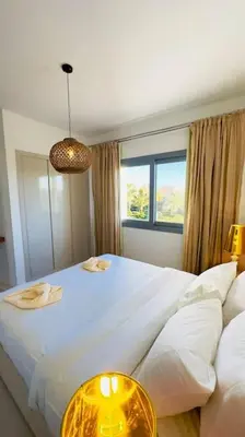a bedroom with a large white bed and a window at Cozy 3 bedrooms in swan lake in Hurghada