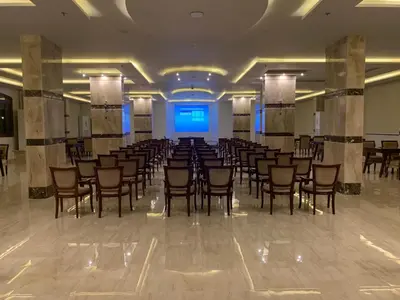 a banquet hall with chairs and a stage in a room at Badr Hotel & Resort El Kharga in Kharga