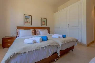 a bedroom with a large bed with blue pillows at Stunning poolhouse duplex - 3 bedrooms - South Marina - El Gouna in Hurghada