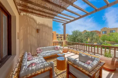 a balcony with couches and a table and chairs at Stunning poolhouse duplex - 3 bedrooms - South Marina - El Gouna in Hurghada