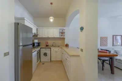 a kitchen with a refrigerator and a dishwasher at Stunning poolhouse duplex - 3 bedrooms - South Marina - El Gouna in Hurghada