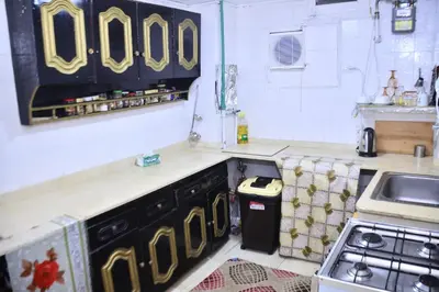 a kitchen with black and gold cabinets and a sink at Alam B&B Luxor in Luxor