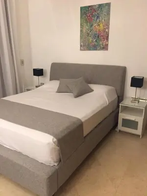 a large bed in a bedroom with two lamps on tables at Modernes Apartment in El Gouna - South Marina in El Gouna