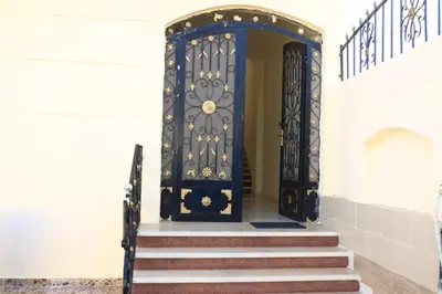 an entrance to a building with a black door at Nille and Garden View Apartment in Jazīrat al ‘Awwāmīyah