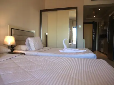 two beds in a hotel room with a swan on them at Sky Relax ALDAU HEIGHTS in Hurghada