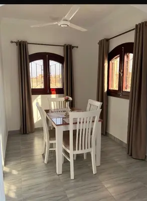 a dining room with a white table and chairs at Villa Muhammad in Quseir