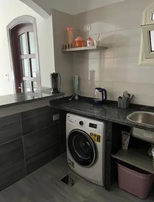 a washing machine in a kitchen next to a sink at Villa Muhammad in Quseir