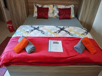 a bed with a red blanket and pillows on it at Studiowohnung auf Poolebene in Hurghada