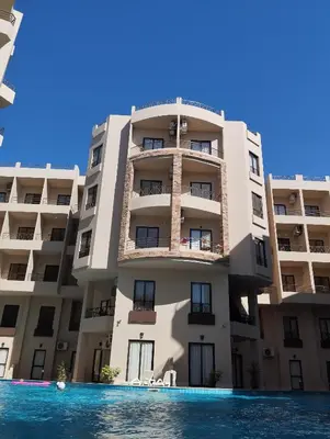 an apartment building with a swimming pool in front of it at Studiowohnung auf Poolebene in Hurghada