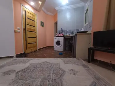 a room with a kitchen with a washing machine at ALHASANI APARTMENT in Hurghada