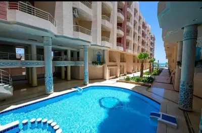 a large swimming pool in front of a building at Kazpilkna Beach Neighborhoods in Hurghada