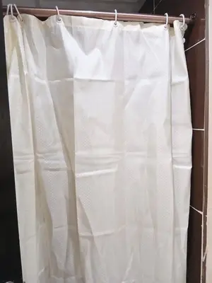 a white shower curtain hanging on a rod at Florenza Khamsin Resort Hurghada in Hurghada