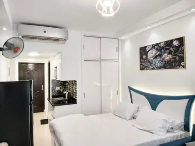 a bedroom with a white bed and a blue chair at Florenza Khamsin Resort Hurghada in Hurghada