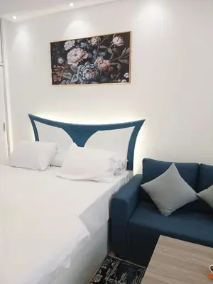 a bed and a blue couch in a room at Florenza Khamsin Resort Hurghada in Hurghada